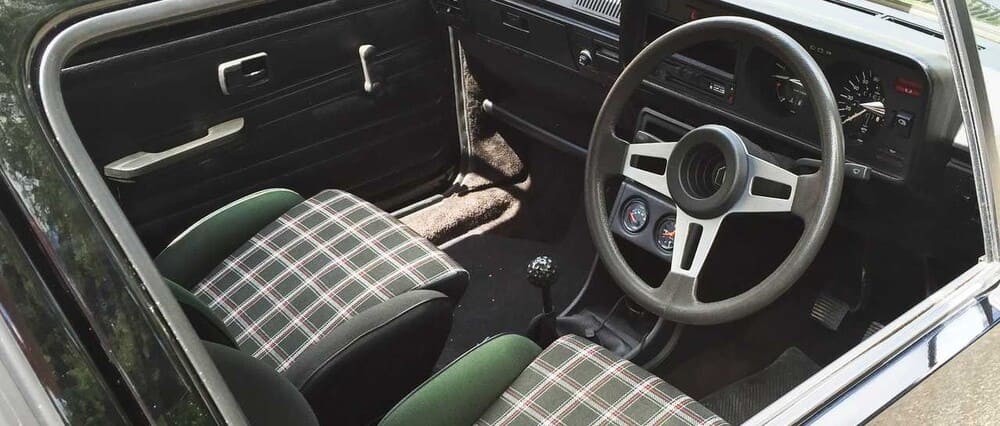 Una foto del interior del Volkswagen Golf GTI, con los estampados tartán y el pomo de la palanca de cambios en forma de pelota de golf